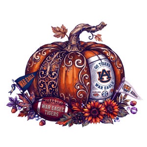 May include: An orange pumpkin with intricate scrollwork, featuring an Auburn University logo, a football labelled War Eagle Tigers, two pennants reading War Eagle and Auburn, and autumn foliage including sunflowers, acorns, and berries.