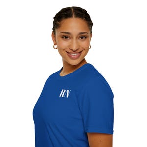 Peut inclure: Un t-shirt bleu roi avec les lettres blanches "RN" imprimées sur le haut de la poitrine gauche. Le t-shirt est fait d'une matière douce et a des manches courtes. La personne sur l'image sourit.