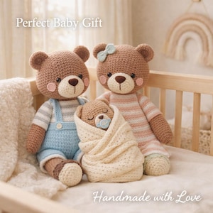 Può includere: Famiglia di orsetti di peluche all'uncinetto, tra cui un orso con tuta blu, un orso con un vestito a righe rosa e un orsetto avvolto in una coperta color crema. L'immagine include il testo "Perfect Baby Gift" e "Handmade with Love".