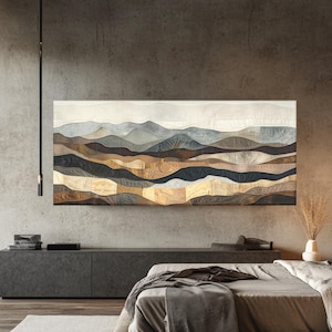 May include: A large, rectangular wall hanging depicting a landscape of rolling hills. The artwork features a patchwork design with various shades of brown, beige, and blue, creating a textured and layered effect. The piece is mounted on a concrete wall above a bed.