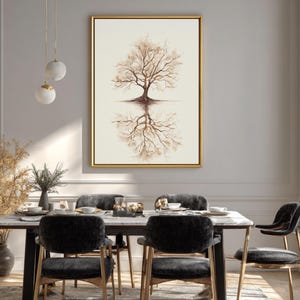 Op de afbeelding: Een ingelijst kunstwerk met een boom en zijn weerspiegeling in een gouden lijst. Het kunstwerk hangt boven een eettafel met zwarte stoelen en een marmeren blad. De kamer heeft neutrale tinten en een modern decor.