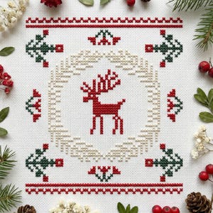 May include: A square, cross-stitch design featuring a red reindeer in the center, surrounded by a beige wreath. The design includes red and green geometric patterns and is set against a white background. The image is framed with natural elements like pine needles and berries.