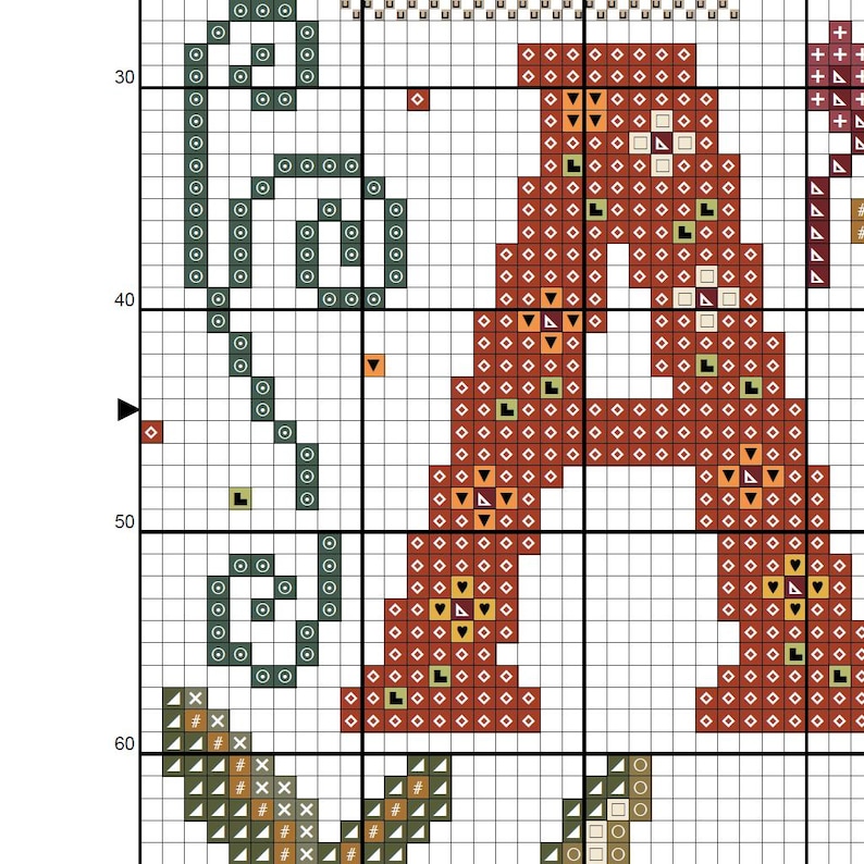 K&ouml;nnte beinhalten: Ein Kreuzstichmuster auf einem Raster mit einem gro&szlig;en Buchstaben A, der mit roten und orangefarbenen geometrischen Symbolen gef&uuml;llt ist. Links befindet sich ein blaugr&uuml;nes Schn&ouml;rkeldesign aus kreisf&ouml;rmigen Symbolen. Dunkelgr&uuml;ne Blattformen sind unten.