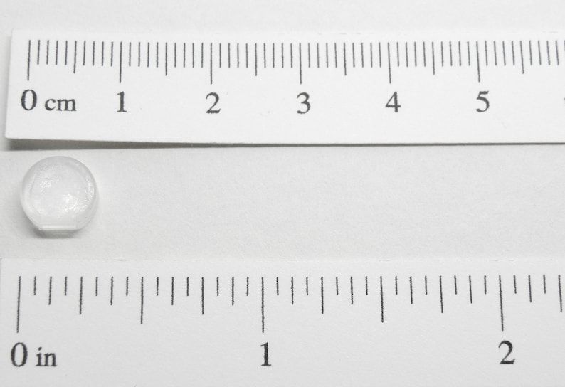 Pu&ograve; includere: Un bottone rotondo in plastica trasparente con un diametro di circa 1,25 cm.