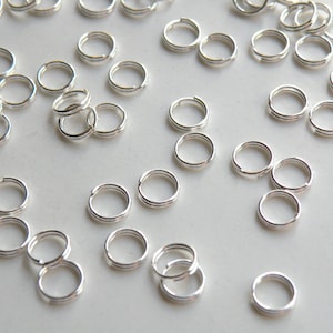 May include: A large quantity of silver jump rings, which are small, circular metal rings used for connecting jewellery components.
