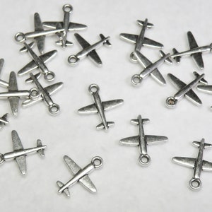 May include: A collection of silver airplane charms. The charms are small and detailed, with a realistic design. They would be perfect for adding a touch of whimsy to jewelry or crafts.