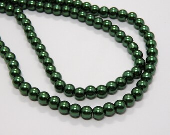 May include: A strand of dark green pearl beads. The beads are round and have a smooth, glossy finish.