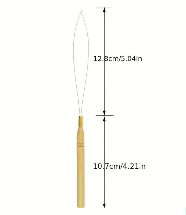 May include: A wooden hair extension tool with a gold-colored metal tip and a thin wire loop. The tool is 4.21 inches long, and the wire loop is 5.04 inches long. The tool is designed for applying hair extensions.