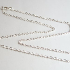 May include: A silver chain necklace with a lobster clasp closure.