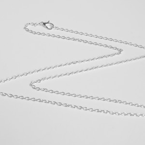 May include: A silver chain necklace with a lobster clasp.