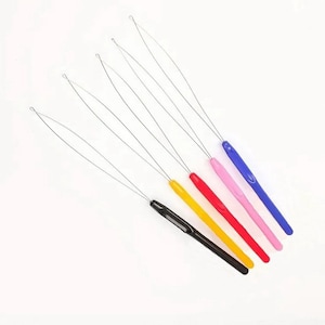 May include: Set of six colourful crochet hooks with metal loops. The hooks are black, yellow, red, pink, and blue.