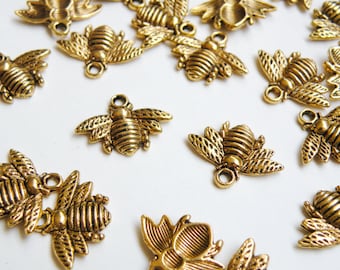 May include: A collection of gold-toned bee charms with intricate details. The charms are perfect for adding a touch of whimsy to jewelry, crafts, and other projects.