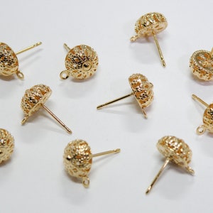 May include: Ten gold-toned earring findings with a filigree design. Each finding has a loop at the top and a post with a backing.