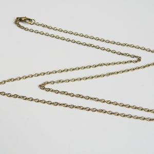 May include: A gold chain necklace with a lobster clasp closure.