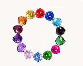 May include: A set of 12 crystal balls in various colors, including red, blue, green, purple, and yellow. The balls are arranged in a circle on a white background.