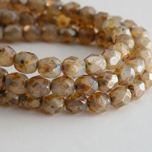 May include: A strand of iridescent brown glass beads with a faceted, hexagonal shape.