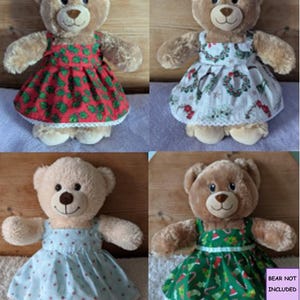May include: Four plush teddy bears wearing different sleeveless dresses with white lace trim at the hem. The dresses feature patterns of red holly, Christmas wreaths, light blue polka dots, and green holiday motifs. Text reads BEAR NOT INCLUDED.