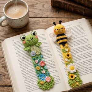 Könnte beinhalten: Zwei handgefertigte Häkel-Lesezeichen: ein grüner Frosch und eine gelbe Biene. Das Frosch-Lesezeichen hat einen grünen Körper mit floralem Design. Das Bienen-Lesezeichen hat schwarz-gelbe Streifen mit floralem Design. Beide liegen in einem offenen Buch.
