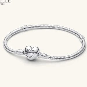Può includere: Un bracciale a catena snake in argento con una chiusura a forma di cuore. La chiusura è incisa con il testo PANDORA e include un piccolo simbolo a corona sopra la lettera O. Il bracciale ha una finitura metallica liscia e flessibile.