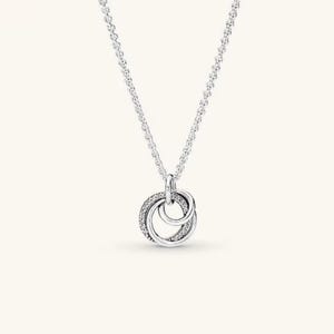 May include: A silver-toned necklace featuring a delicate chain and a pendant composed of two interlocking circular rings. One ring is plain and smooth, while the other is encrusted with small, clear stones. The text AURELLE JEWELS appears in the top left corner.