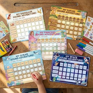 May include: Colorful children's reward charts with various themes, including dinosaurs, safari animals, a princess, ocean creatures, and space. Each chart has spaces for daily goals and rewards, with crayons and markers nearby.