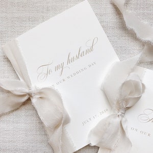 Puede incluir: Una tarjeta blanca con el texto "To my husband on our wedding day" y la fecha "July 17, 2020". La tarjeta est&aacute; atada con una cinta blanca.