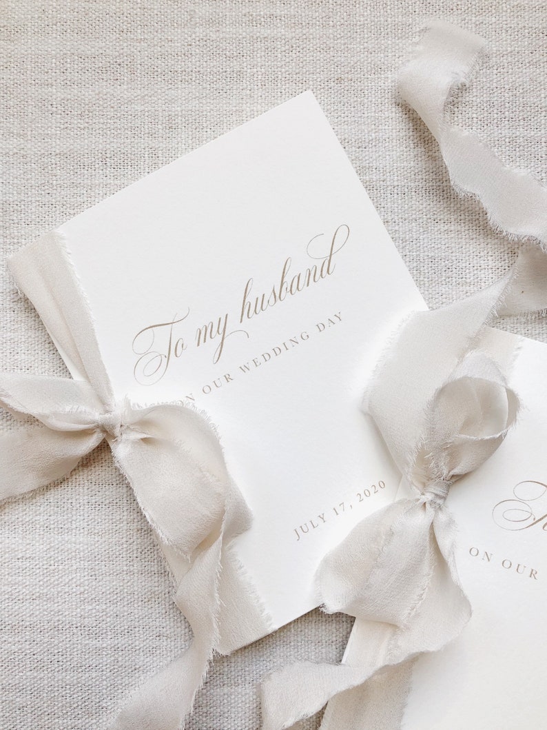 Puede incluir: Una tarjeta blanca con el texto "To my husband on our wedding day" y la fecha "July 17, 2020". La tarjeta est&aacute; atada con una cinta blanca.