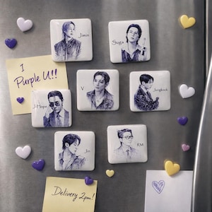 May include: Seven square white magnets featuring detailed blue ink sketches of individual portraits, each labelled with names: Jimin, Suga, V, Jungkook, J-Hope, Jin, and RM. Includes small heart-shaped magnets and two yellow sticky notes with text.