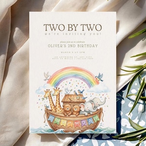 May include: A cream-coloured birthday invitation with the text "TWO BY TWO" and "OLIVER'S 2ND BIRTHDAY." The invitation features a watercolour illustration of Noah's Ark with animals, a rainbow, and the word "BIRTHDAY" on a banner.