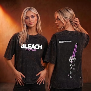Könnte beinhalten: Ein anthrazitfarbenes T-Shirt in Acid-Wash-Optik mit dem weißen Schriftzug BLEACH und rosa japanischen Schriftzeichen auf der Vorderseite. Die Rückseite zeigt eine Schwertgrafik mit dem Text SENBONZAKURA Bankai und kleinen rosa Blütenblättern.