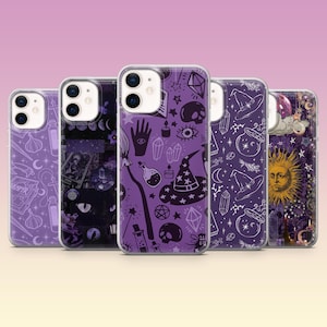 May include: Five phone cases with mystical and witchy designs. The cases have purple and black backgrounds with white illustrations of witch hats, crystals, skulls, and celestial elements. The cases are made of clear plastic.
