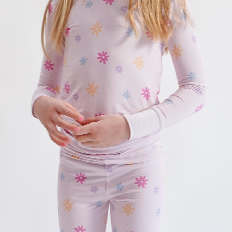 Peut inclure: Ensemble de pyjama rose clair avec un motif floral dans les tons de jaune, bleu et rose. Le haut &agrave; manches longues et le pantalon assorti sont en mati&egrave;re douce. Les poignets des manches sont blancs.