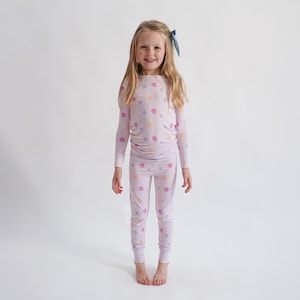 Peut inclure: Un ensemble de pyjama lilas avec un motif floral. Le haut &agrave; manches longues et le pantalon assorti pr&eacute;sentent un motif r&eacute;p&eacute;t&eacute; de fleurs aux couleurs pastel. Le pyjama est fait d'une mati&egrave;re douce et confortable.