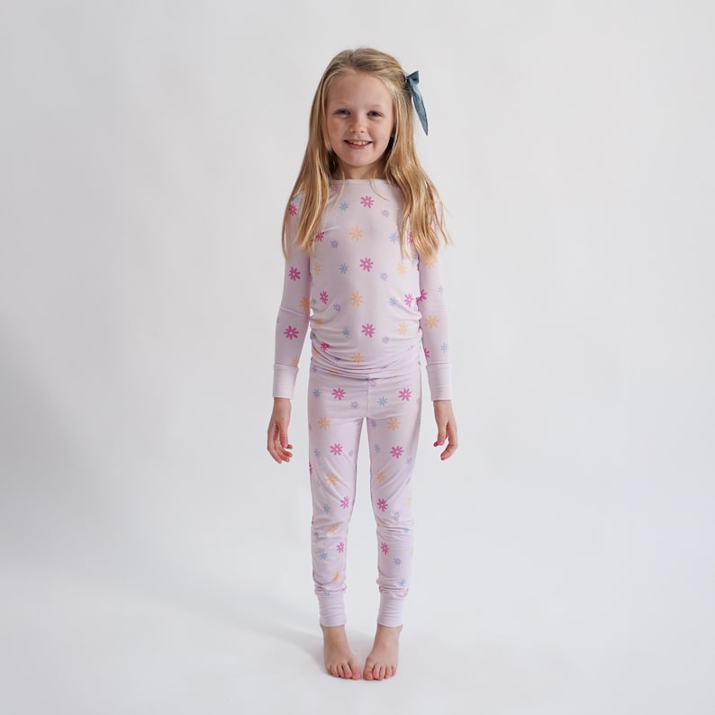 Peut inclure: Un ensemble de pyjama lilas avec un motif floral. Le haut &agrave; manches longues et le pantalon assorti pr&eacute;sentent un motif r&eacute;p&eacute;t&eacute; de fleurs aux couleurs pastel. Le pyjama est fait d'une mati&egrave;re douce et confortable.