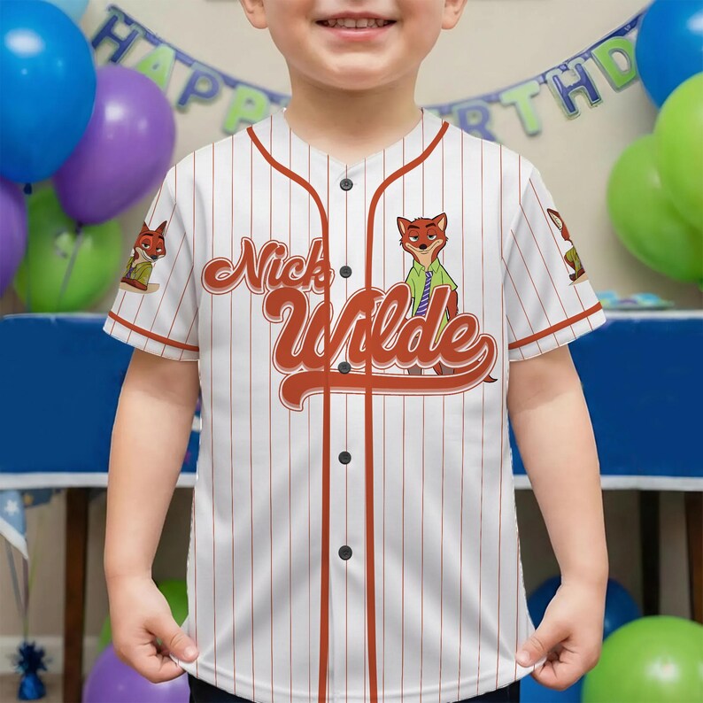 May include: White baseball jersey with red pinstripes and accents. The jersey features the name "Nick Wilde" in a stylized font, along with a cartoon fox character. The jersey has black buttons and short sleeves.