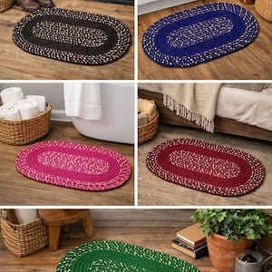 Puede incluir: Cinco alfombras ovaladas trenzadas en varios colores: negro, azul, rosa, burdeos y verde. Cada alfombra tiene una textura trenzada con un color contrastante tejido. Estas alfombras son adecuadas para baños, entradas o dormitorios.