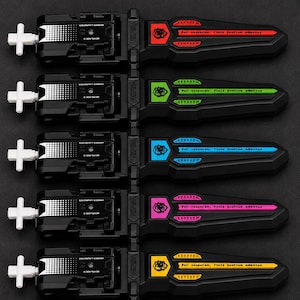 Puede incluir: Primer plano de cinco lanzadores de juguetes negros con asas blancas y detalles coloridos. Cada lanzador tiene un detalle de color diferente: rojo, verde, azul, rosa y amarillo. El texto "Per asperam, finis beatum adventus" est&aacute; impreso en cada lanzador.