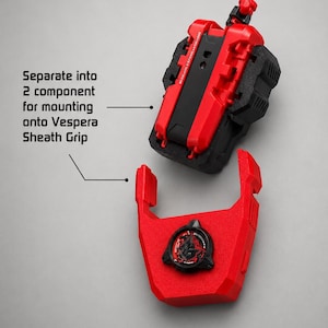 May include: A red and black mechanical component that separates into two parts for mounting onto a Vespera Sheath Grip. The top section is a textured block, while the bottom section features a circular emblem with a stylised graphic design.