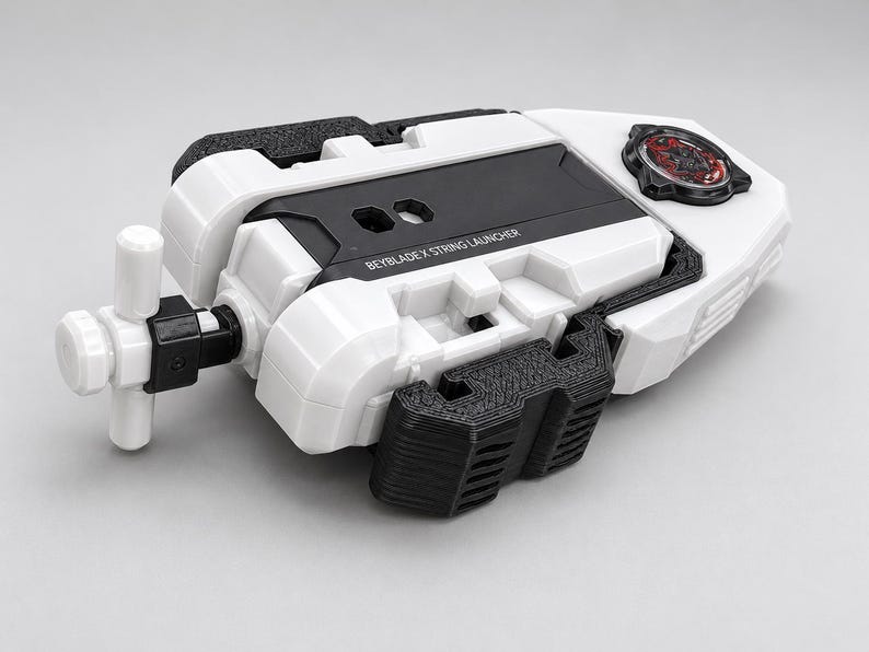 May include: A white and black Beyblade X string launcher featuring a T-shaped handle, a central black panel with the text BEYBLADE X STRING LAUNCHER, and a circular red and black emblem on the top right section of the plastic housing.