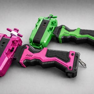 Puede incluir: Tres lanzadores de juguetes coloridos en rosa y verde con detalles en negro. Los lanzadores tienen un mango y un mecanismo de disparo. Los juguetes est&aacute;n dise&ntilde;ados para lanzar otros juguetes. El fondo es gris liso.