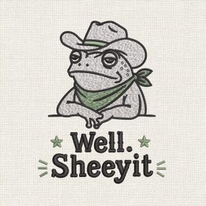 Puede incluir: Un diseño de bordado que muestra un sapo gris con sombrero de vaquero y un pañuelo verde. Debajo del sapo, el texto Well. Sheeyit aparece en negro, flanqueado por dos estrellas verdes y líneas horizontales decorativas sobre tela blanca.
