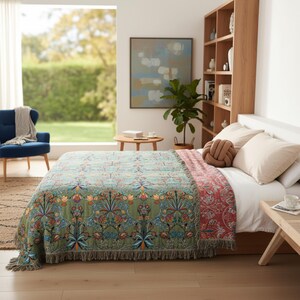 Peut inclure: Une couverture décorative à motifs floraux verts et rouges, avec des franges, recouvrant un lit. Le lit est fait de draps blancs et d'oreillers. La pièce comprend une bibliothèque en bois et un fauteuil bleu.