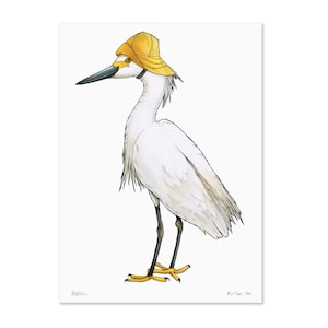 May include: A watercolour illustration of a white egret wearing a yellow hat. The bird has a long black beak and legs, with yellow feet. The artwork is set against a white background.