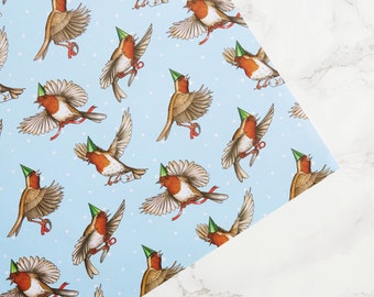 May include: Blue wrapping paper with a repeating pattern of robins wearing party hats. The robins are holding small gifts and are flying in different directions.