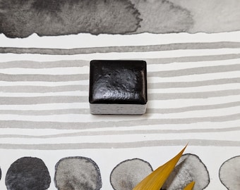 Dark granular grey: a very dark, slightly granulating, neutral gray handmade watercolour paint. In 3 pan sizes. Vegan watercolor binder.