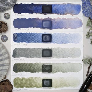 Light on the Fens - unique handmade watercolour set of 6 sky & water hues. Handmade watercolor paint in blues, violet, grey, greens. 3 sizes