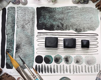 Pine black: granulating black with a deep green undertone. Handmade granulating watercolour paint in 3 pan sizes, vegan watercolor binder
