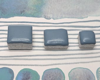 Lights in the mist: pale blue granulating handmade watercolour paint with colourful undertones. Vegan watercolor paints in half/quarter pans