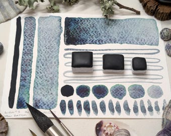 Lights in the night: black granulating handmade watercolour paint with colourful undertone. Vegan watercolor. Full, half, quarter, mini pans