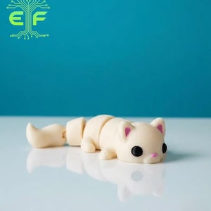 May include: A segmented, off-white cat figurine with black eyes and pink inner ears and nose. The tail is detached, and the cat is lying down. The background is a solid teal color.